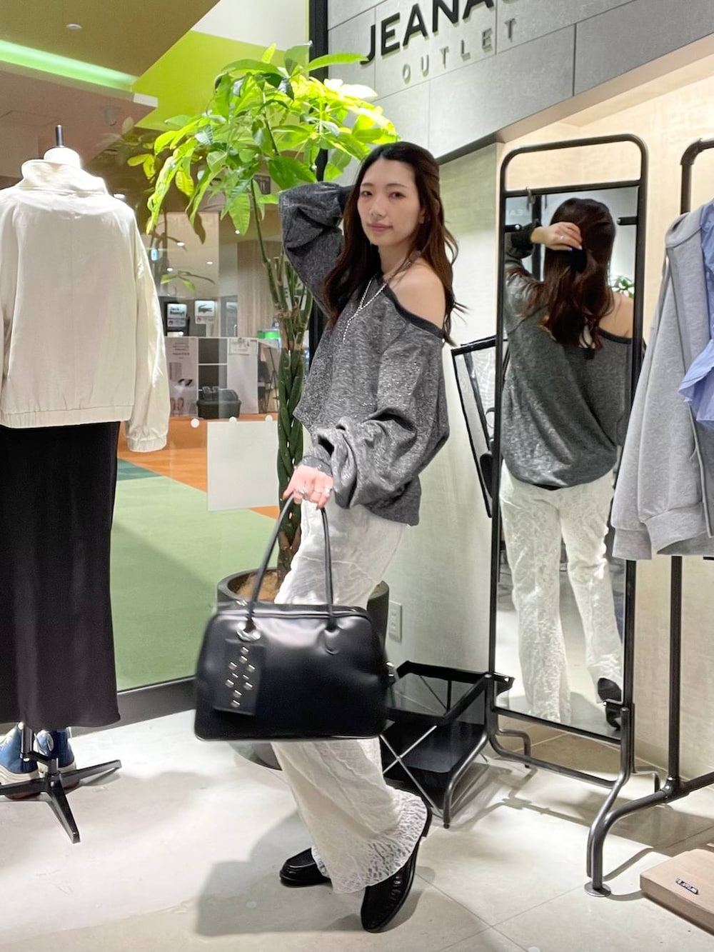 ブラック系のスウェット、ブラック系のボストンバッグ、ブラック系のローファーを着用したレディースの春コーディネートの2枚目の写真