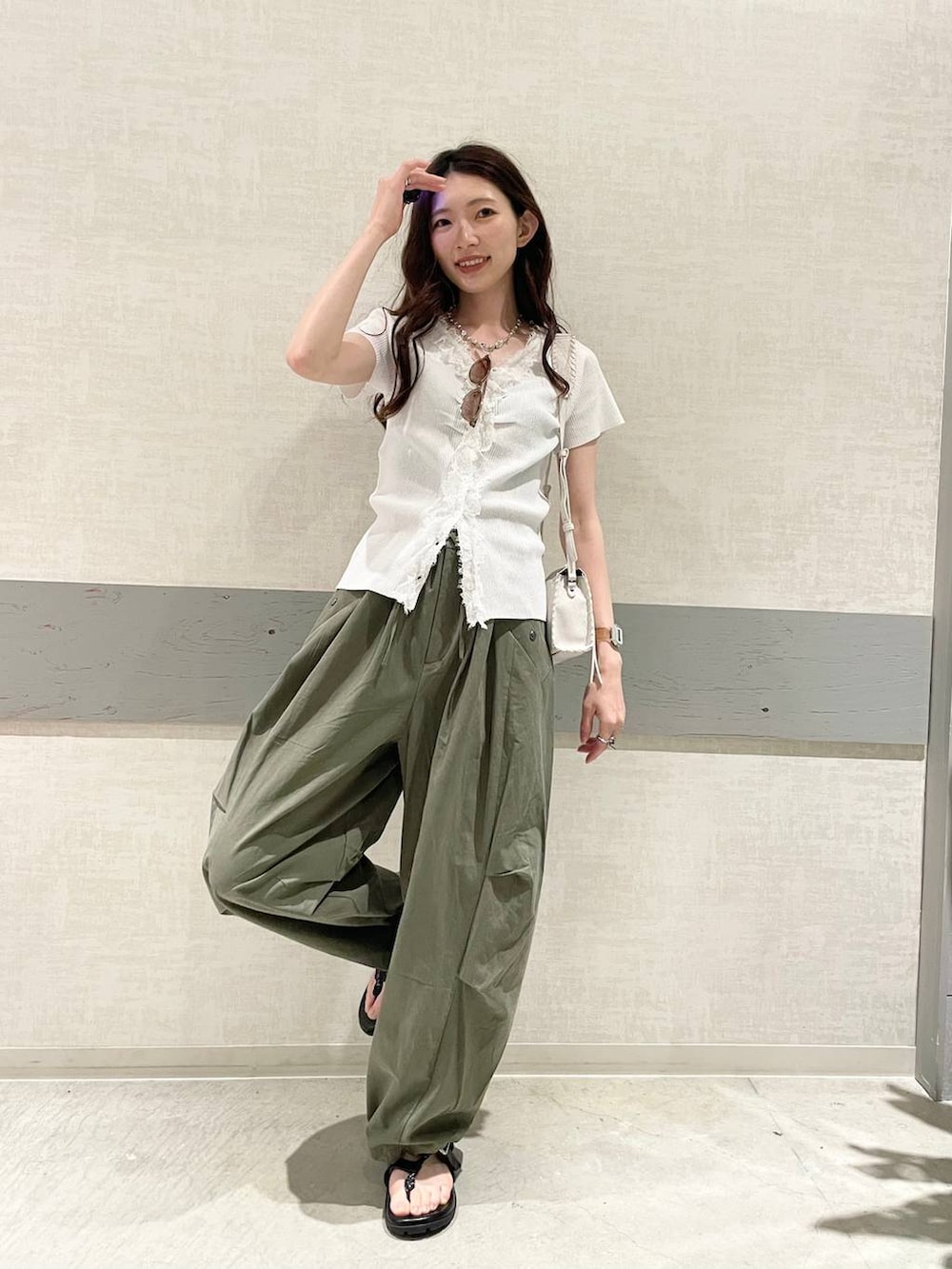 グリーン系のその他パンツ、ホワイト系のショルダーバッグ、ブラック系のサンダルを着用したレディースの夏コーディネートの2枚目の写真