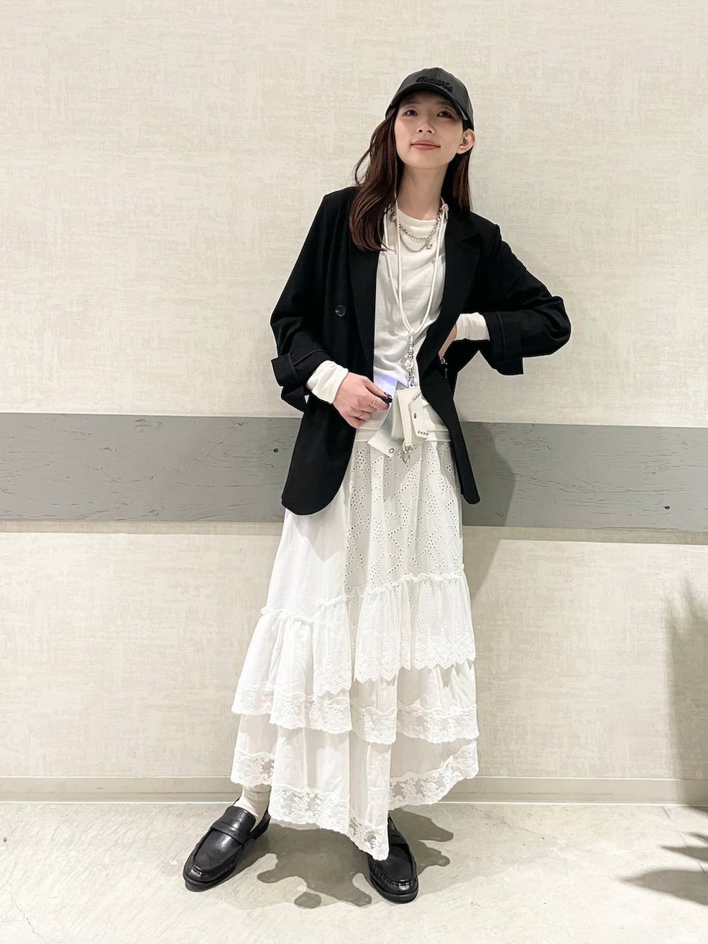 ホワイト系のTシャツ/カットソー、ブラック系のテーラードジャケット、ブラック系のローファーを着用したレディースの冬コーディネートの5枚目の写真