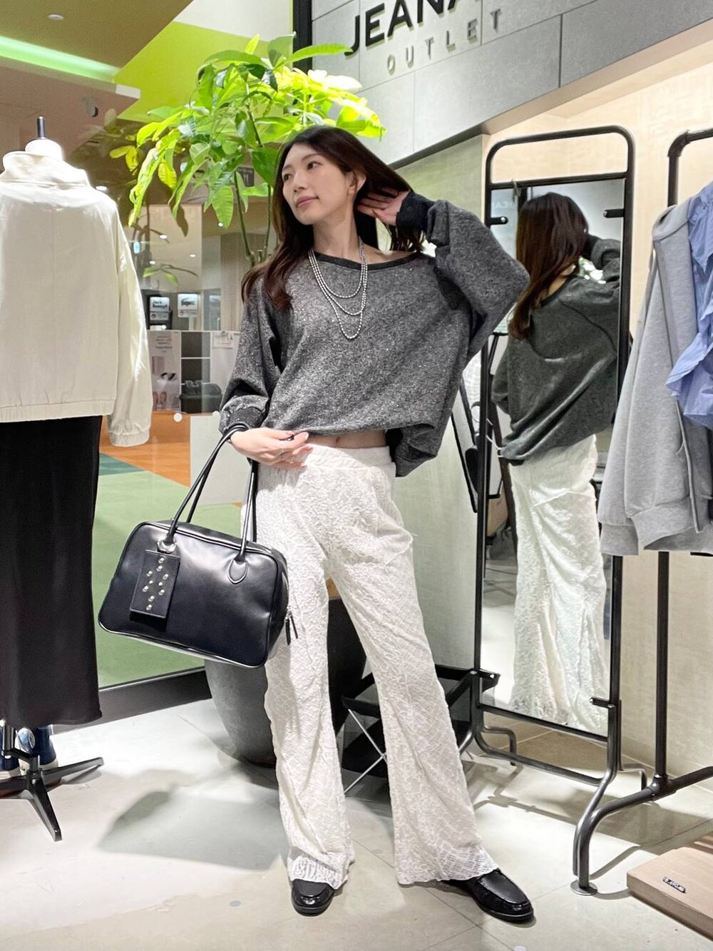 ブラック系のスウェット、ブラック系のボストンバッグ、ブラック系のローファーを着用したレディースの春コーディネートの4枚目の写真