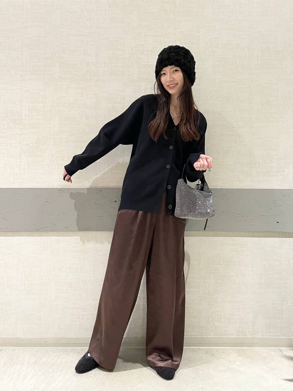 ブラック系のパンプス、ブラック系のハンドバッグ、ブラック系のカーディガン/ボレロを着用したレディースの冬コーディネートの4枚目の写真