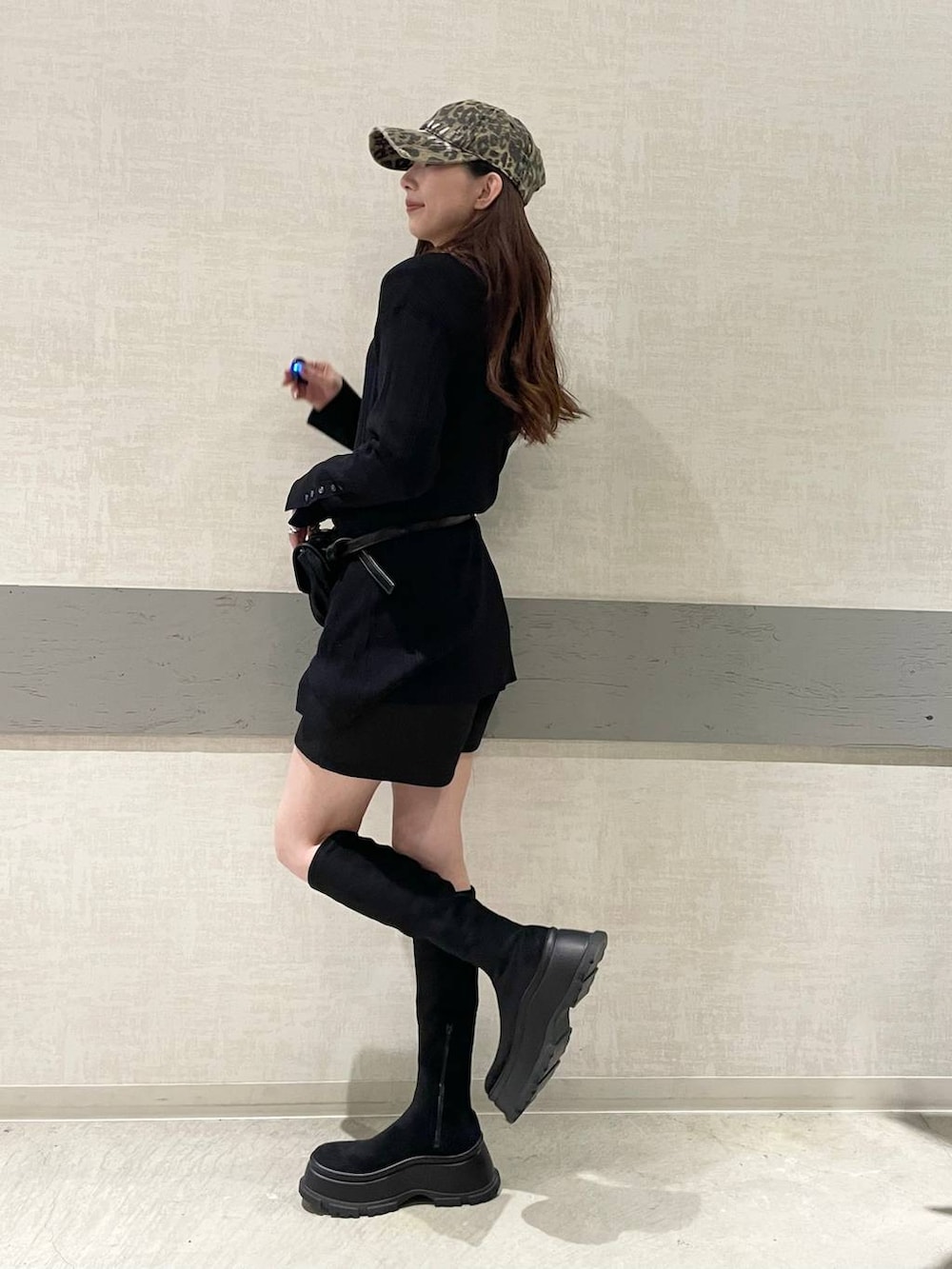 ブラック系のショルダーバッグ、ブラック系のブーツ、ブラック系のセットアップを着用したレディースの冬コーディネートの4枚目の写真