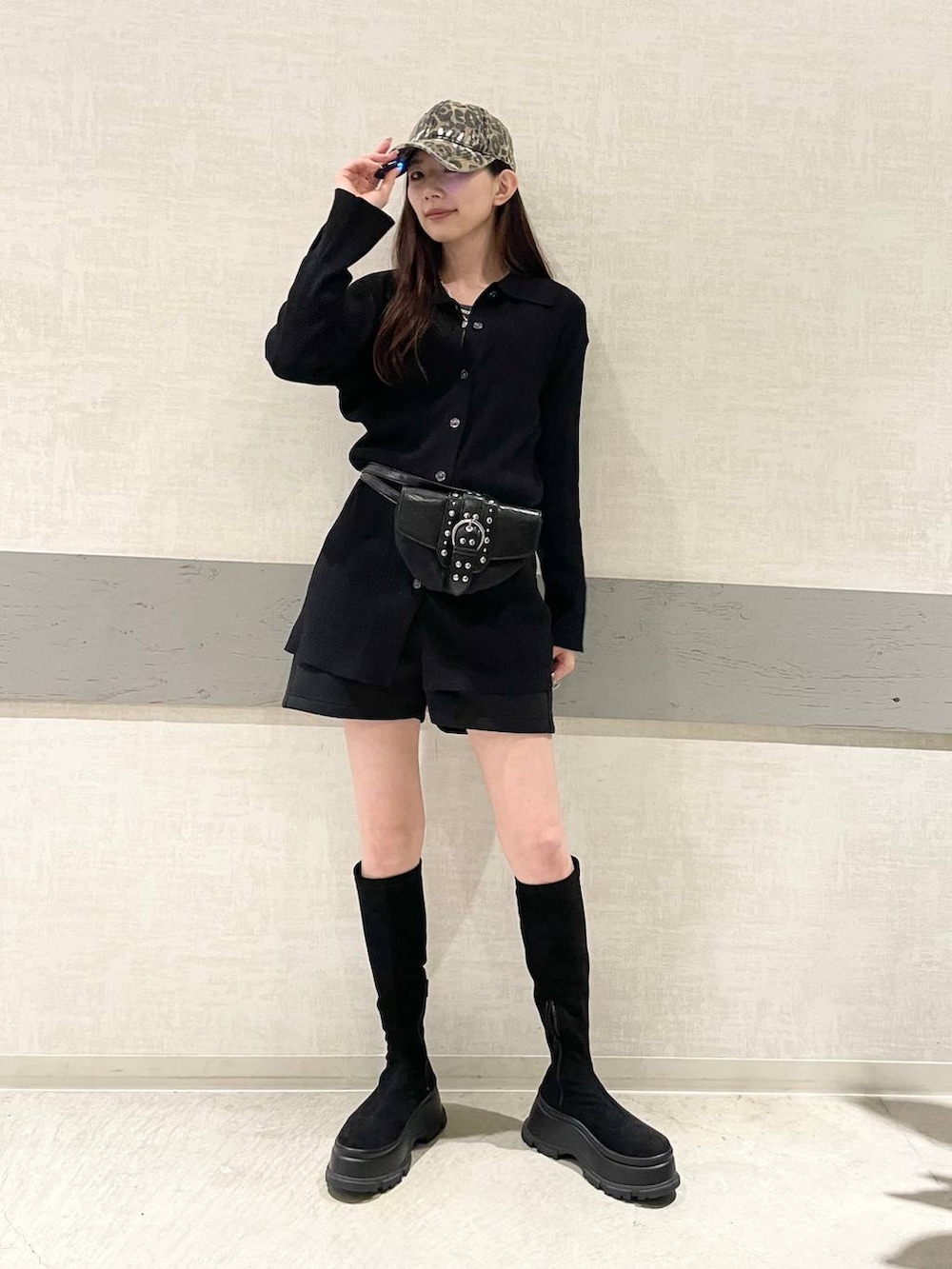 ブラック系のショルダーバッグ、ブラック系のブーツ、ブラック系のセットアップを着用したレディースの冬コーディネートの2枚目の写真