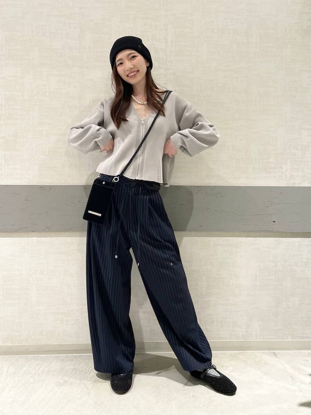 ブラック系のパンプス、ブルー系のスラックス、グレー系のカーディガン/ボレロを着用したレディースの春コーディネートの2枚目の写真