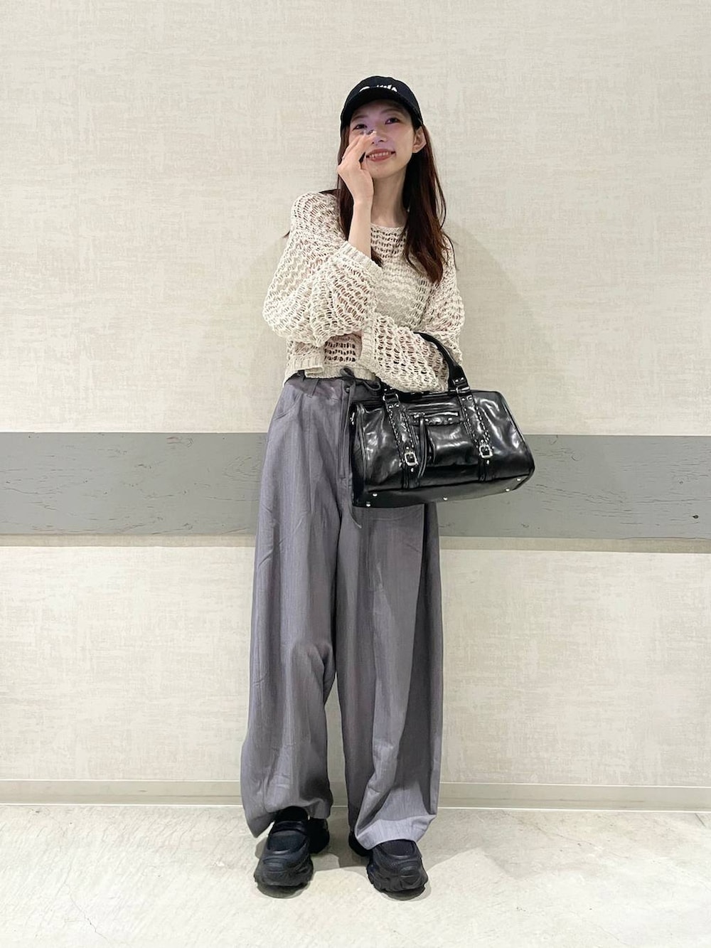 ブラック系のローファー、ブラック系のボストンバッグ、ピンク系のニット/セーターを着用したレディースの春コーディネートの5枚目の写真