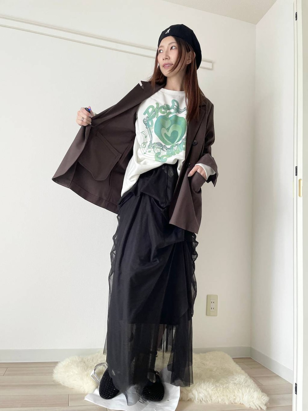 ブラック系のパンプス、ブラウン系のテーラードジャケットを着用したレディースの春コーディネートの2枚目の写真