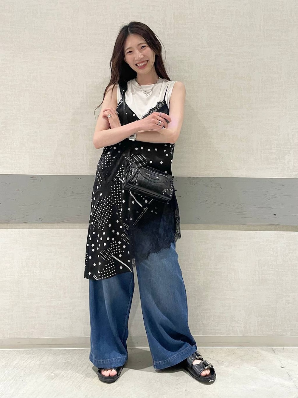 グリーン系のTシャツ/カットソー、ブラック系のサンダル、ブルー系のデニムパンツを着用したレディースの夏コーディネートの4枚目の写真
