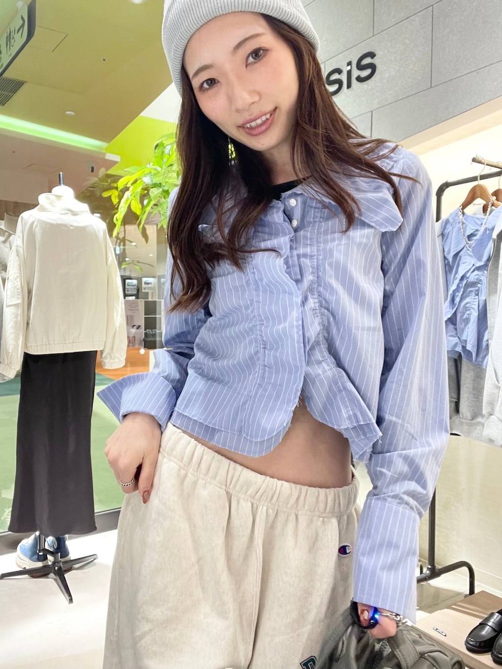 シルバー系のスニーカー、ベージュ系のスウェットパンツ、グリーン系のボストンバッグを着用したレディースの春コーディネートの4枚目の写真