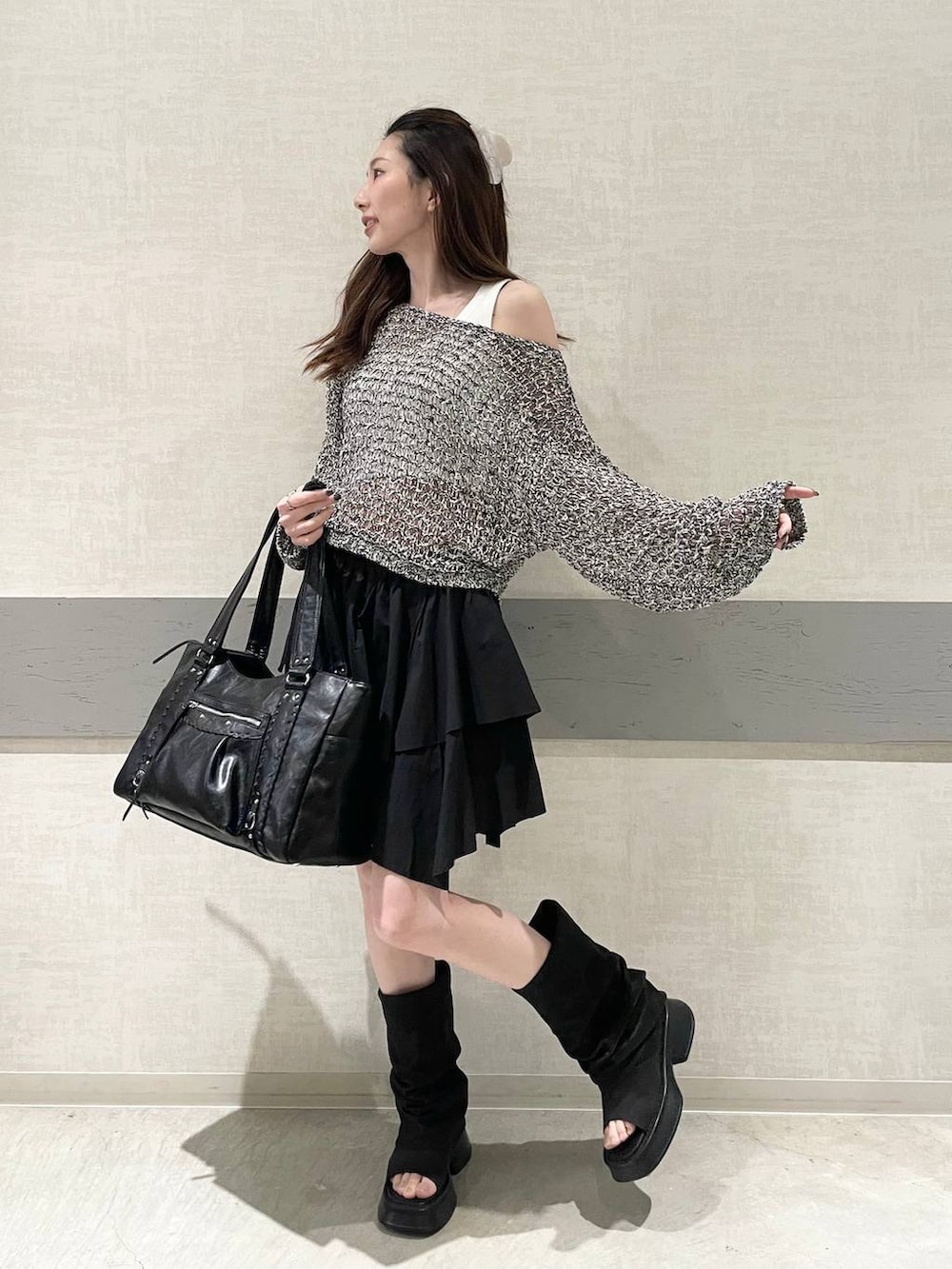 ホワイト系のタンクトップ、ブラック系のトートバッグ、ブラック系のスカートを着用したレディースの春コーディネートの4枚目の写真