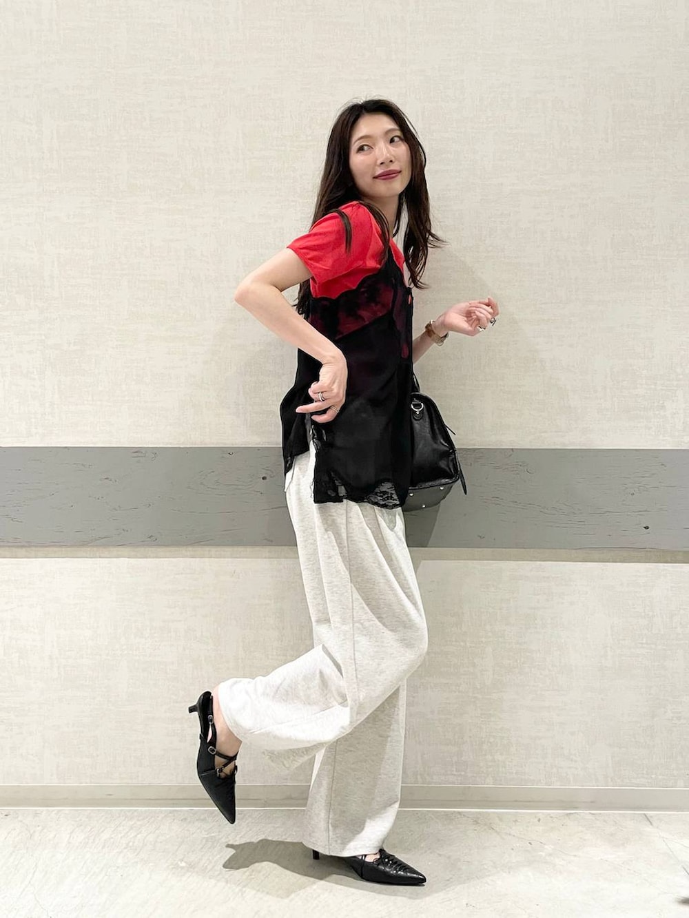 ブラック系のボストンバッグ、ブラック系のパンプス、レッド系のTシャツ/カットソーを着用したレディースの夏コーディネートの4枚目の写真