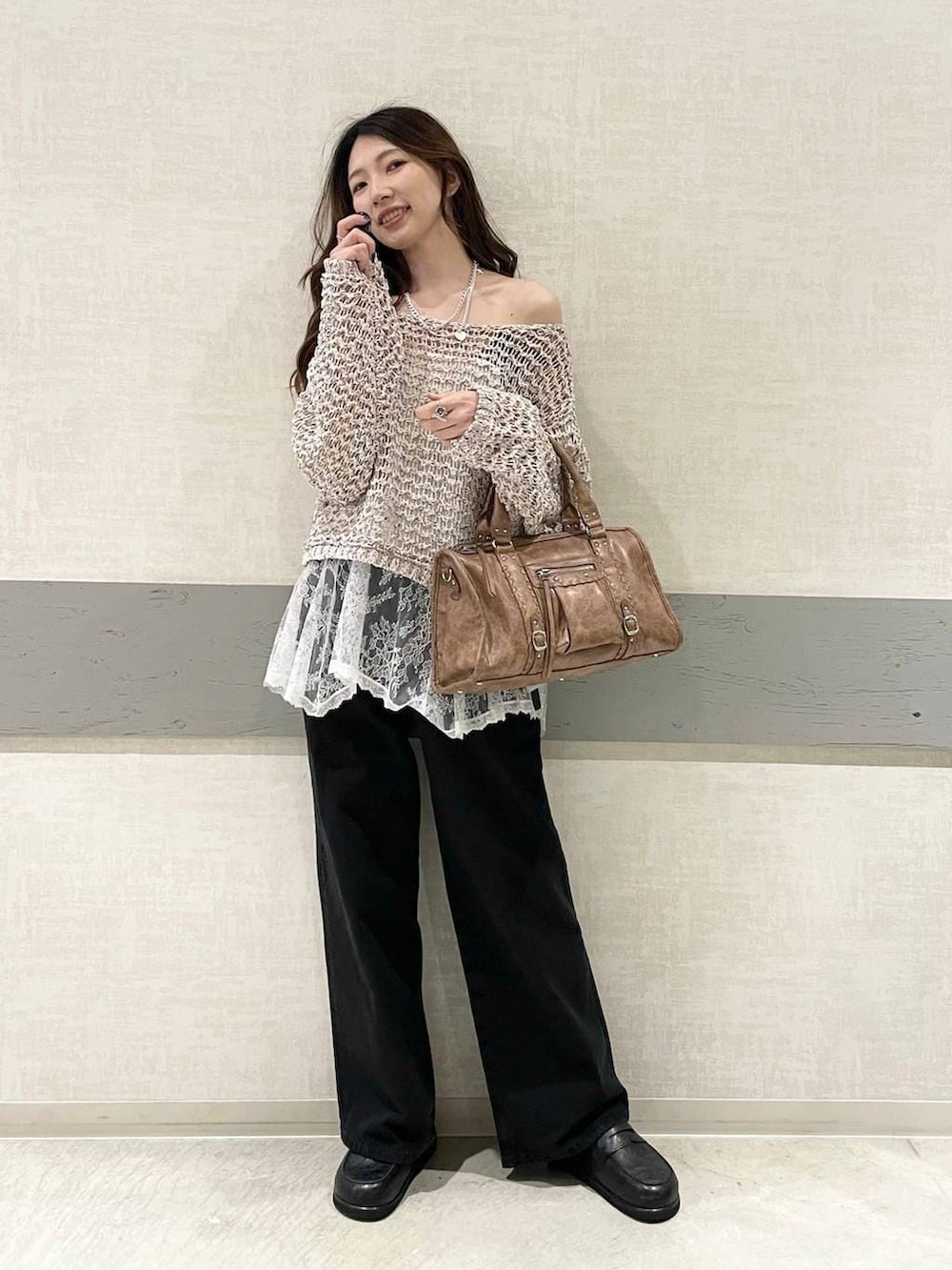 ブラック系のローファー、ブラック系のボストンバッグ、ブラック系のデニムパンツを着用したレディースの春コーディネートの4枚目の写真