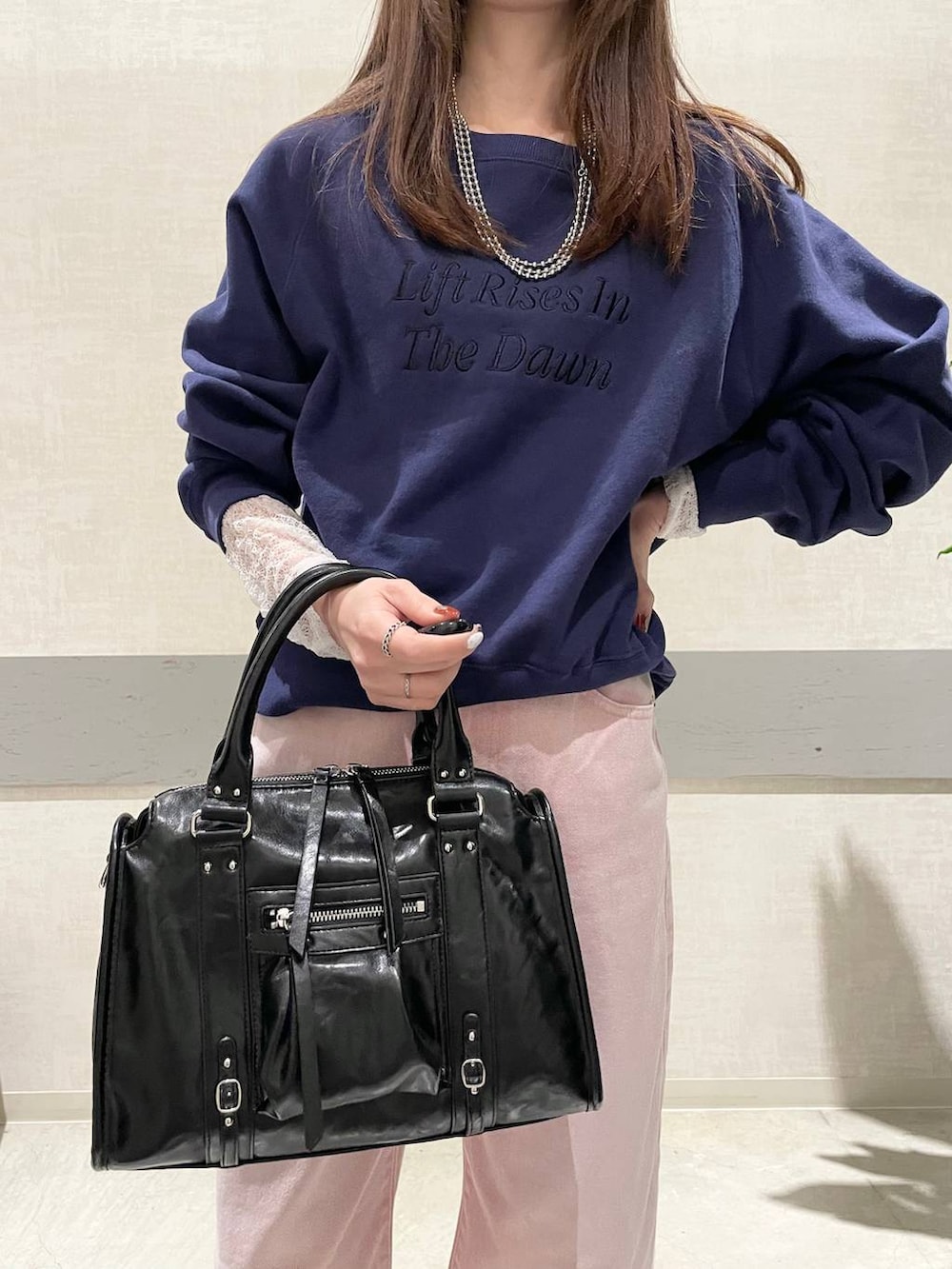 ブラック系のボストンバッグ、ブラック系のパンプス、ホワイト系のTシャツ/カットソーを着用したレディースの冬コーディネートの6枚目の写真