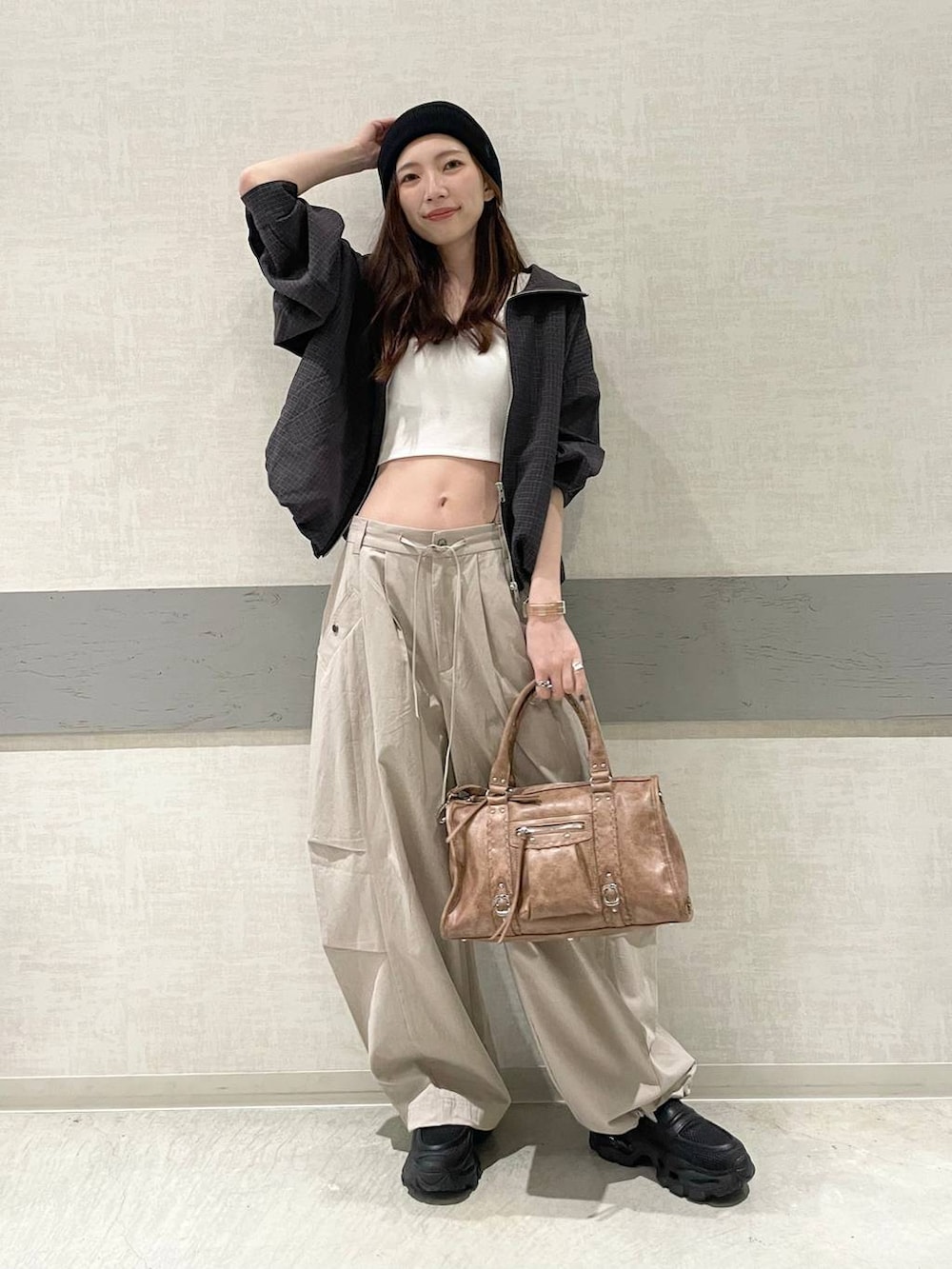 ホワイト系のタンクトップ、ブラック系のローファー、ブラウン系のボストンバッグを着用したレディースの春コーディネートの2枚目の写真