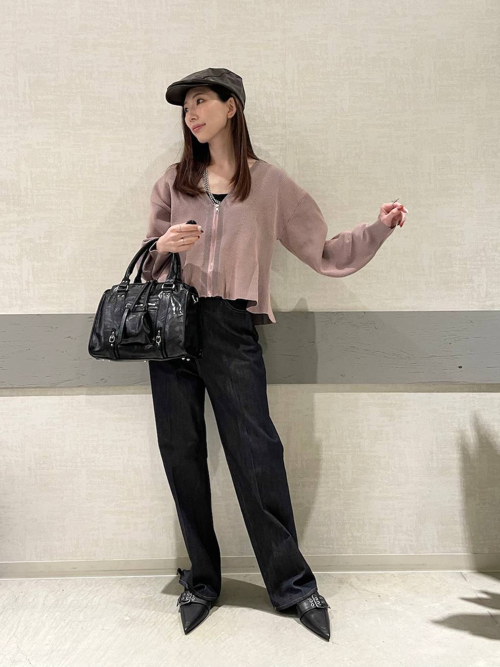 ブラック系のボストンバッグ、ブラック系のパンプス、ブルー系のデニムパンツを着用したレディースの冬コーディネートの2枚目の写真