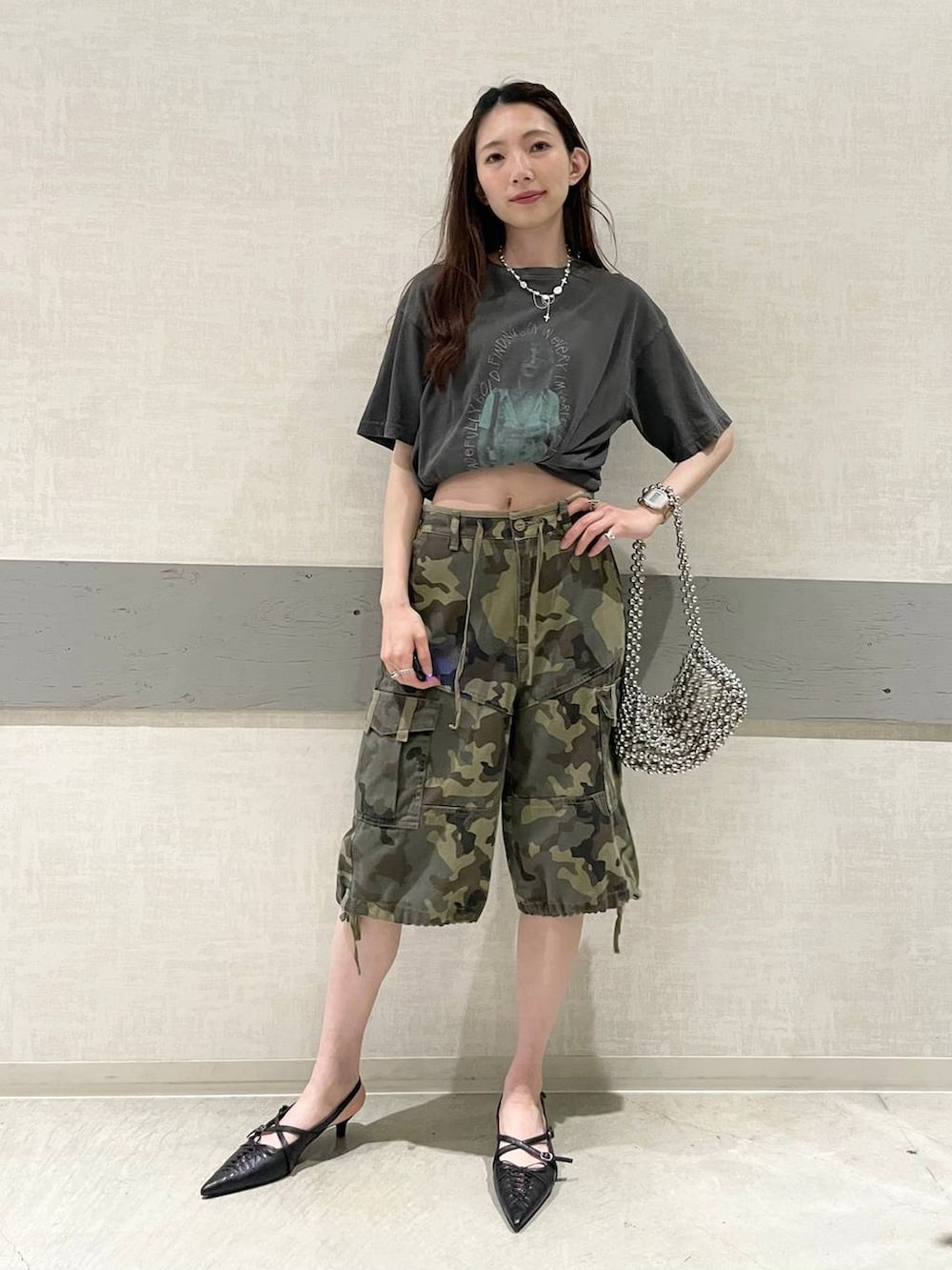 グレー系のTシャツ/カットソー、シルバー系のハンドバッグ、ブラック系のパンプスを着用したレディースの夏コーディネートの3枚目の写真