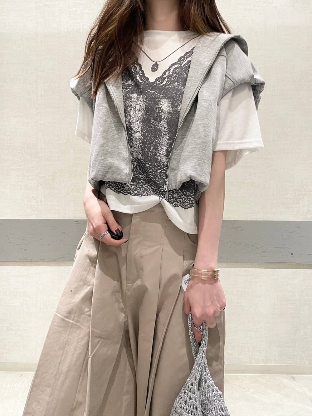 ブラック系のローファー、シルバー系のショルダーバッグ、グレー系のベストを着用したレディースの春コーディネートの6枚目の写真