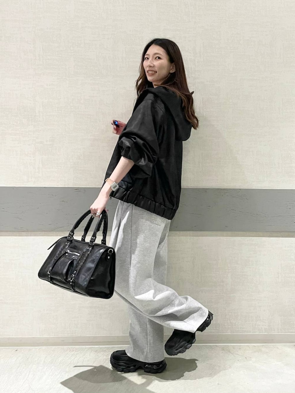 ブラック系のローファー、ブラック系のボストンバッグ、ブラック系のブルゾンを着用したレディースの春コーディネートの2枚目の写真