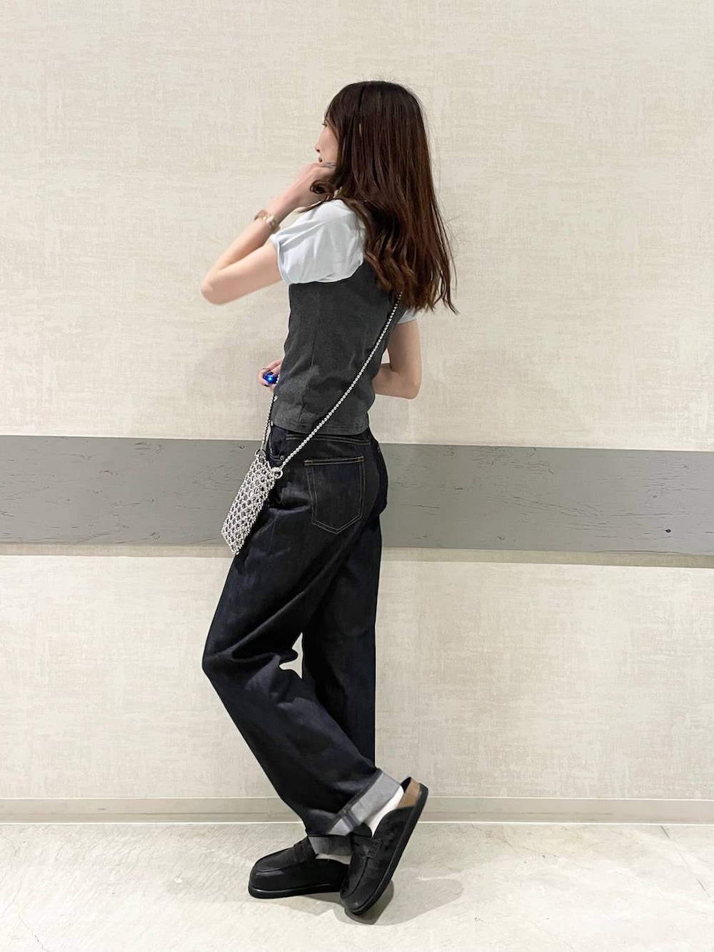 ブラック系のローファー、ブルー系のデニムパンツ、グレー系のタンクトップを着用したレディースの春コーディネートの3枚目の写真