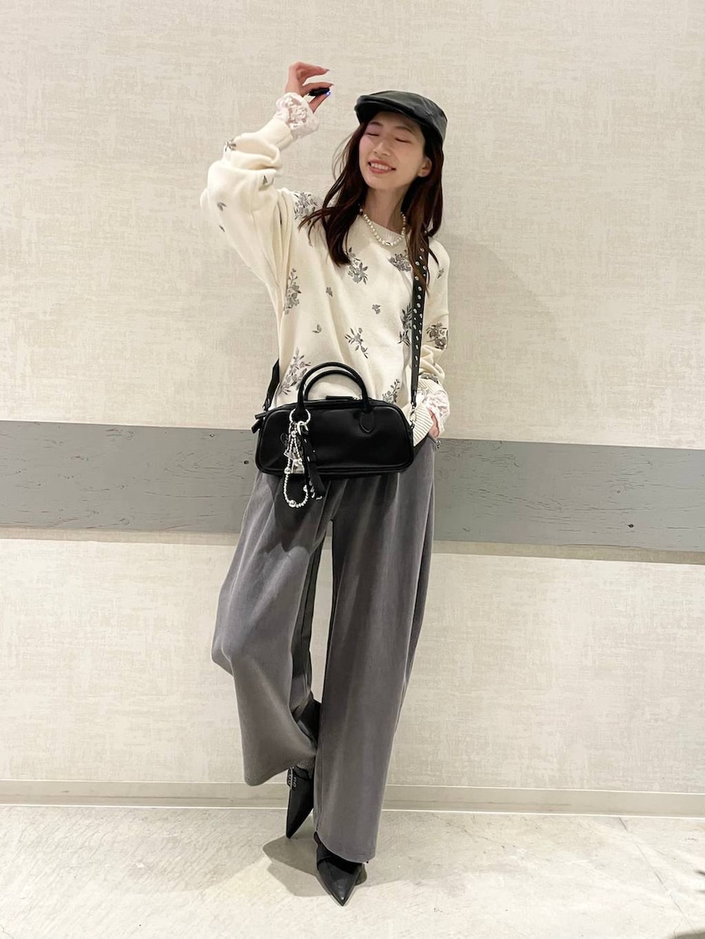 ブラック系のボストンバッグ、ブラック系のパンプス、ホワイト系のニット/セーターを着用したレディースの春コーディネートの4枚目の写真