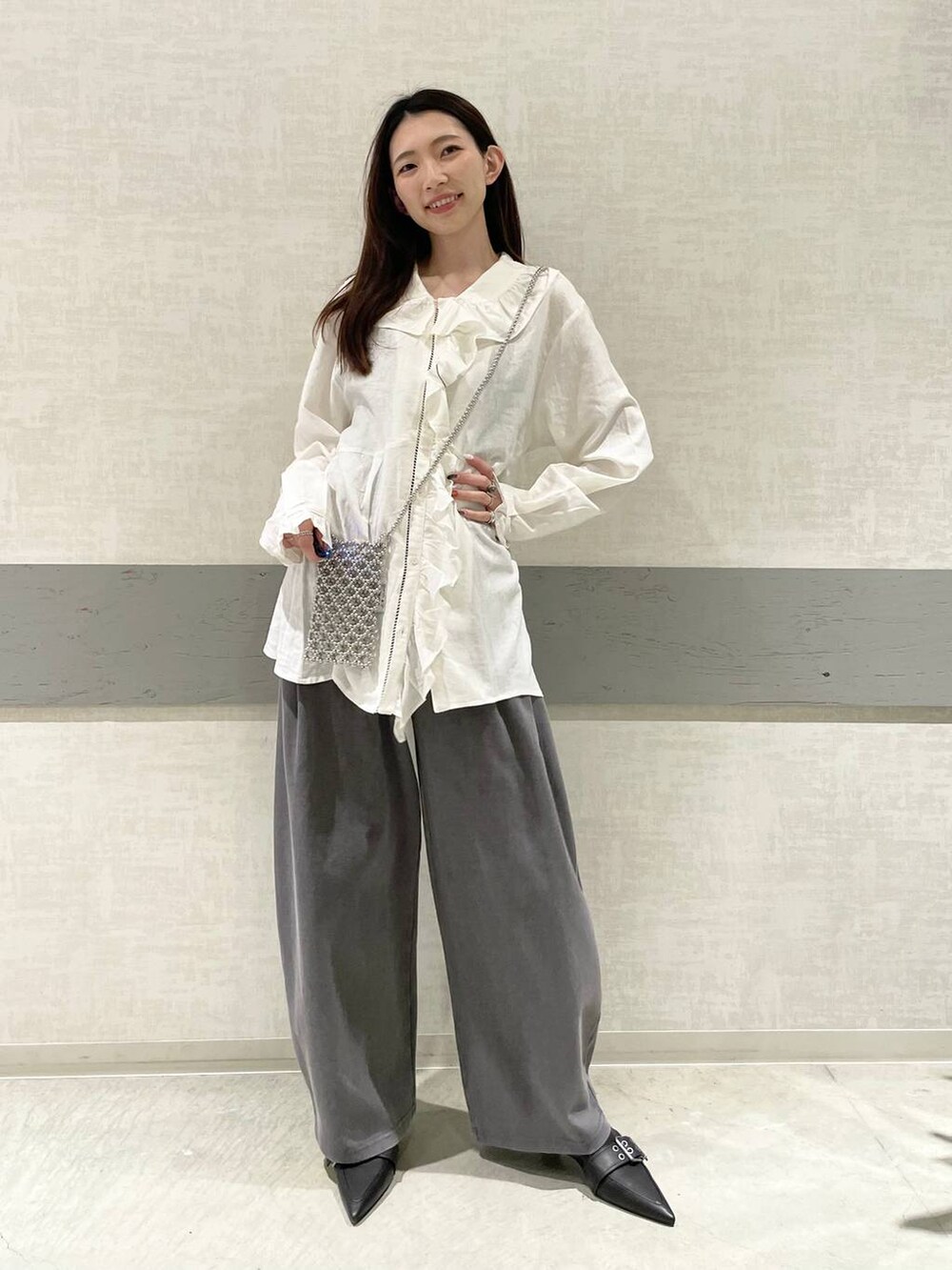 ブラック系のパンプス、グレー系のスウェットパンツ、ホワイト系のチュニックを着用したレディースの春コーディネートの3枚目の写真