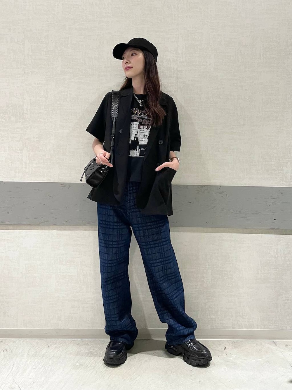 ブルー系のデニムパンツ、ブラック系のTシャツ/カットソー、ブラック系のローファーを着用したレディースの夏コーディネートの3枚目の写真