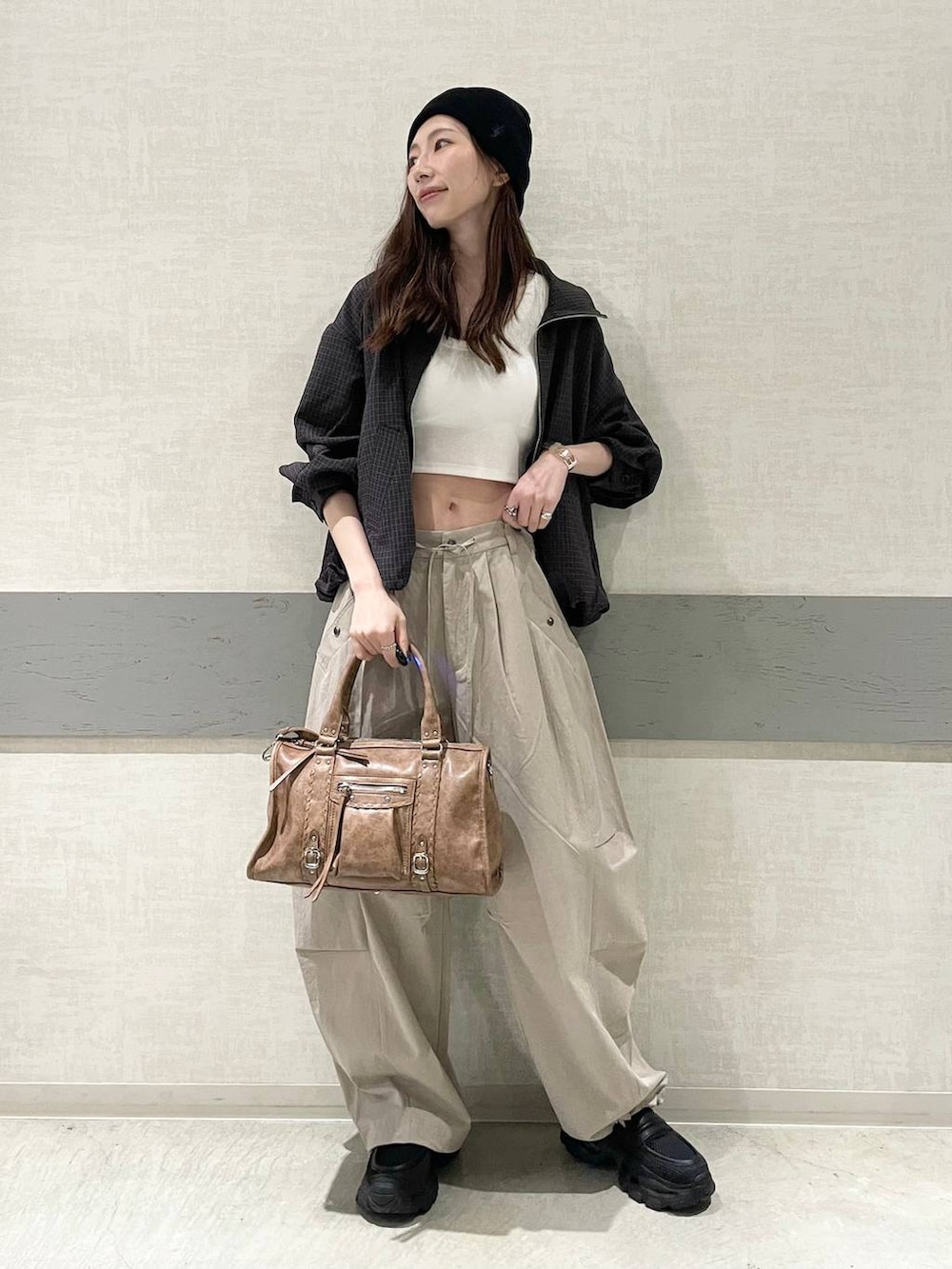 ホワイト系のタンクトップ、ブラック系のローファー、ブラウン系のボストンバッグを着用したレディースの春コーディネートの5枚目の写真