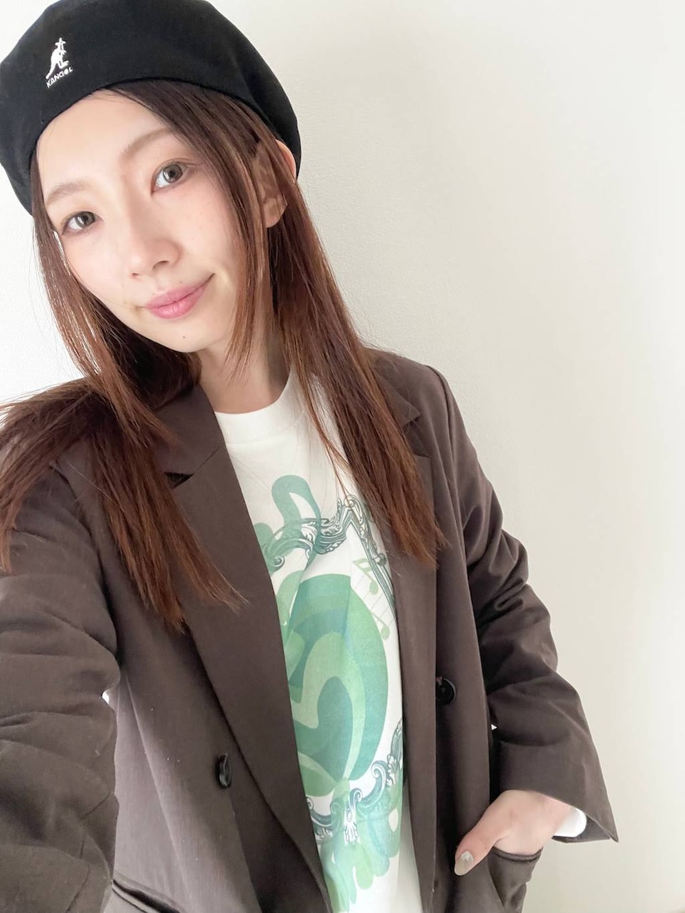 ブラック系のパンプス、ブラウン系のテーラードジャケットを着用したレディースの春コーディネートの3枚目の写真