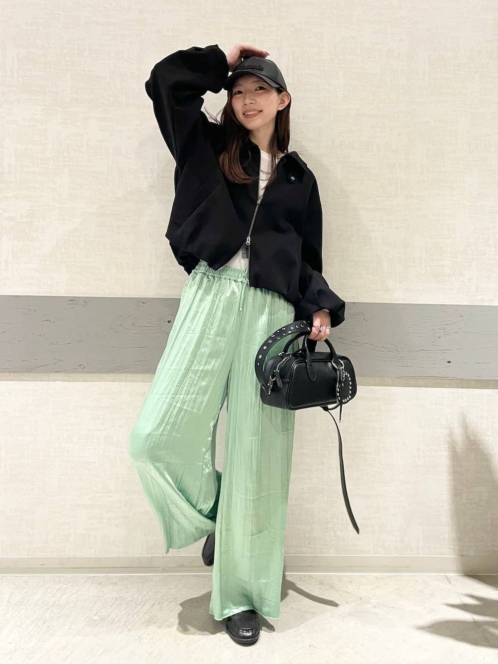 ホワイト系のTシャツ/カットソー、ブラック系のボストンバッグ、ブラック系のブルゾンを着用したレディースの冬コーディネートの2枚目の写真