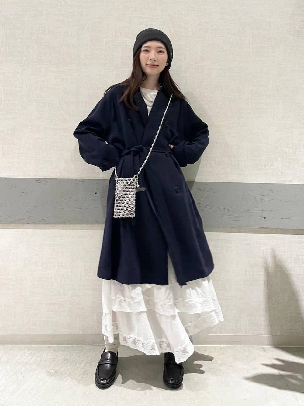 ホワイト系のTシャツ/カットソー、ブルー系のトレンチコート、ブラック系のローファーを着用したレディースの冬コーディネートの4枚目の写真