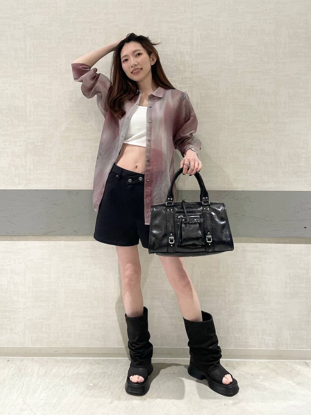 ホワイト系のタンクトップ、ブラック系のスウェットパンツ、ブラック系のボストンバッグを着用したレディースの春コーディネートの2枚目の写真