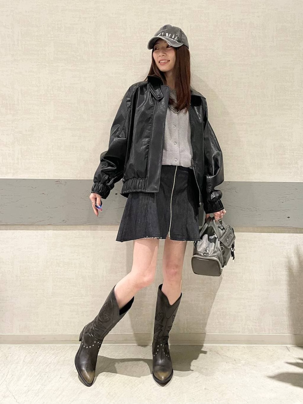 ブラック系のブーツ、グリーン系のボストンバッグ、ブラック系のブルゾンを着用したレディースの冬コーディネートの3枚目の写真