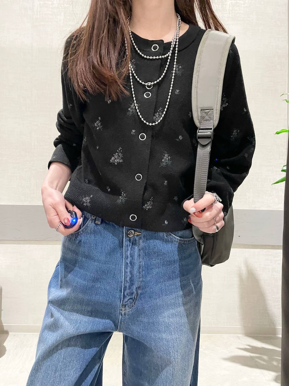 ブラック系のパンプス、グリーン系のバックパック/リュック、ブルー系のデニムパンツを着用したレディースの冬コーディネートの3枚目の写真