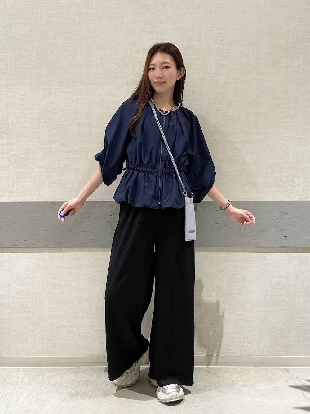 ホワイト系のスニーカー、ブラック系のその他パンツ、ブルー系のシャツ/ブラウスを着用したレディースの秋コーディネートの3枚目の写真