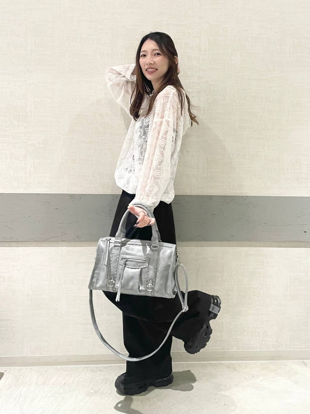 ブラック系のローファー、ブルー系のボストンバッグ、ホワイト系のパーカーを着用したレディースの春コーディネートの2枚目の写真