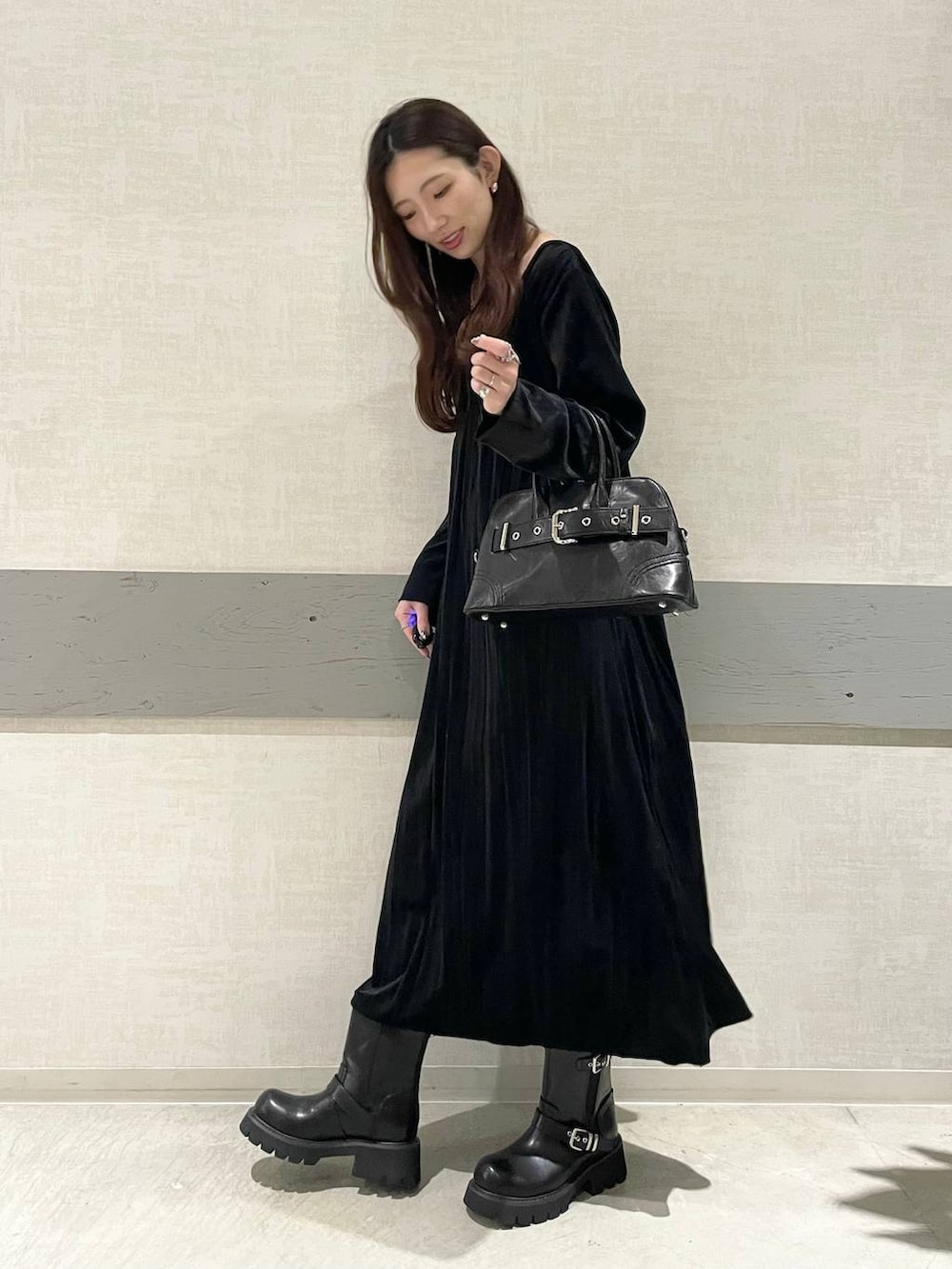 ブラック系のブーツ、ブラック系のボストンバッグ、ブラック系のワンピースを着用したレディースの秋コーディネートの2枚目の写真