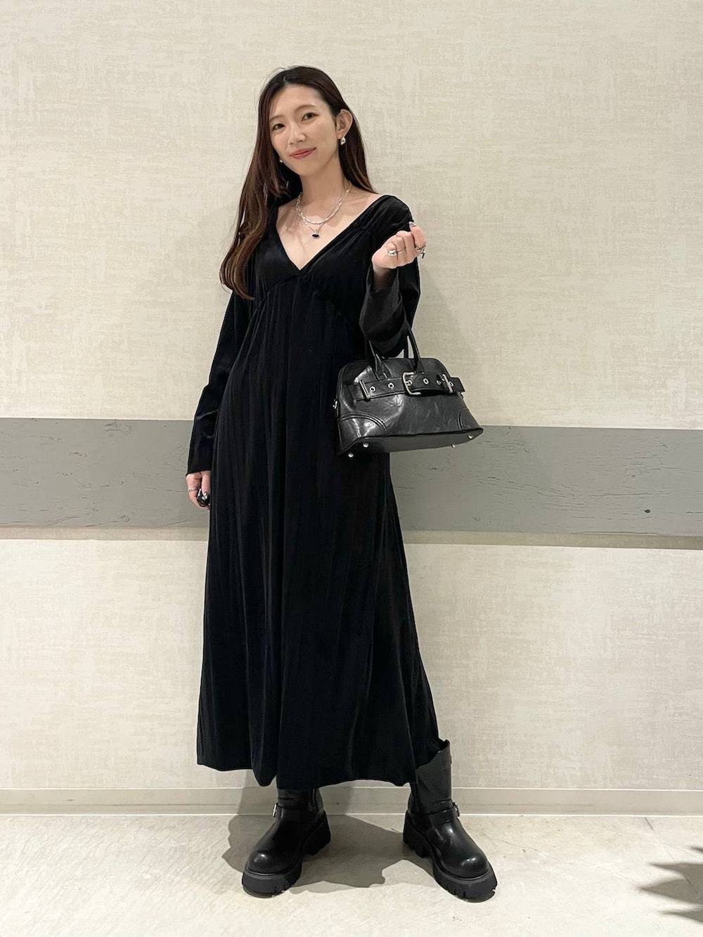 ブラック系のブーツ、ブラック系のボストンバッグ、ブラック系のワンピースを着用したレディースの秋コーディネートの3枚目の写真