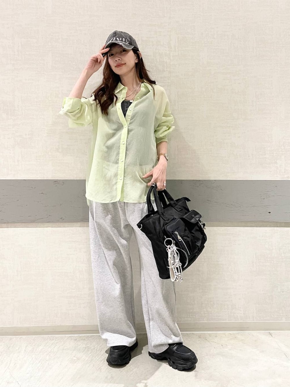 ブラック系のローファー、ブラック系のトートバッグ、グリーン系のシャツ/ブラウスを着用したレディースの春コーディネートの2枚目の写真