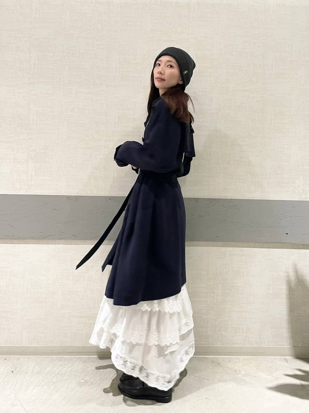 ホワイト系のTシャツ/カットソー、ブルー系のトレンチコート、ブラック系のローファーを着用したレディースの冬コーディネートの5枚目の写真