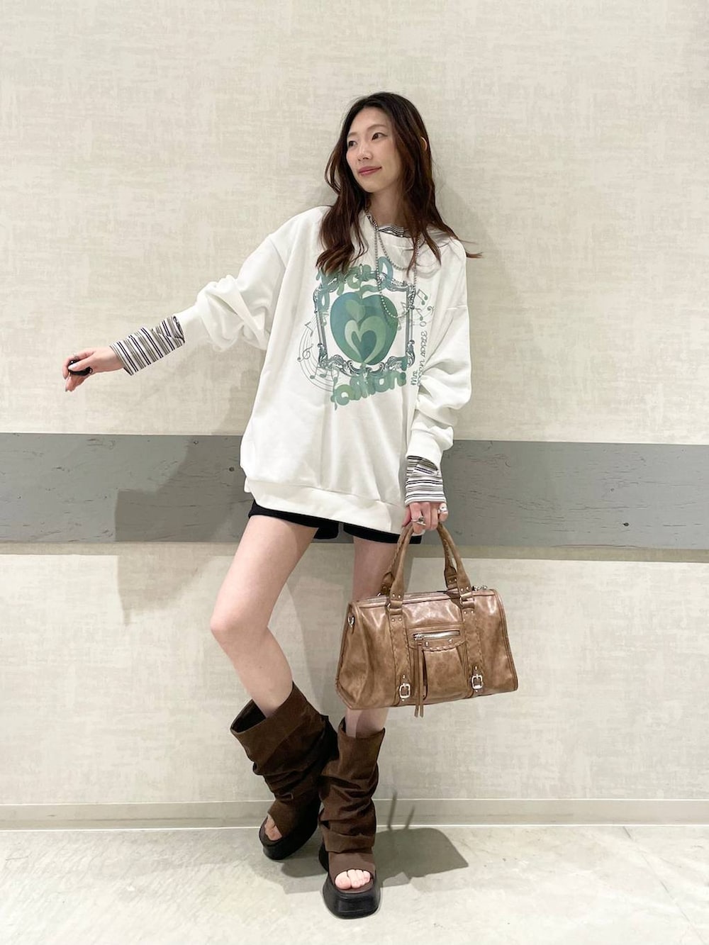 ホワイト系のTシャツ/カットソー、ブラック系のスウェットパンツ、ブラウン系のボストンバッグを着用したレディースの春コーディネートの3枚目の写真
