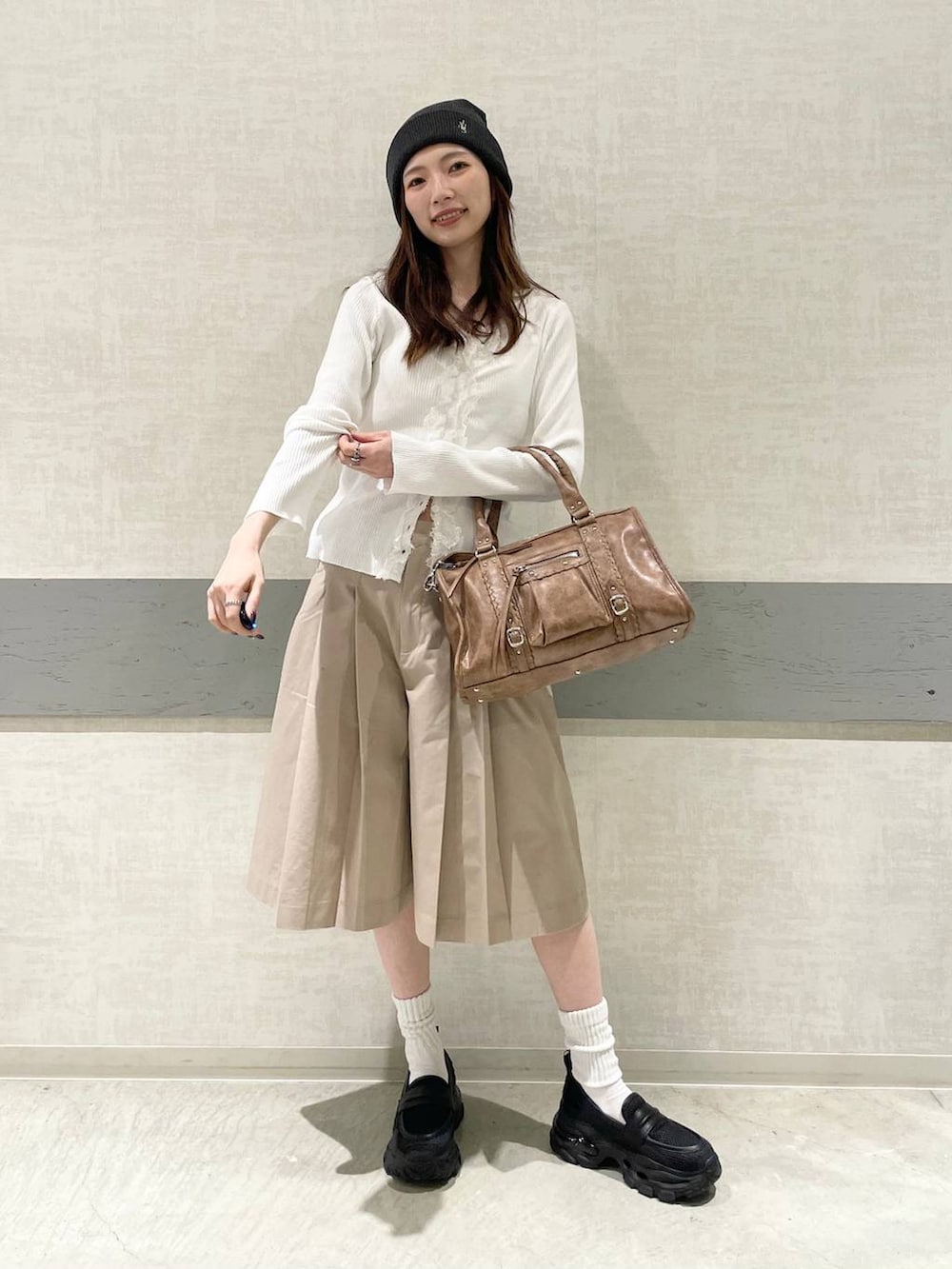 ブラック系のローファー、ブラウン系のボストンバッグ、ベージュ系のその他パンツを着用したレディースの春コーディネートの4枚目の写真