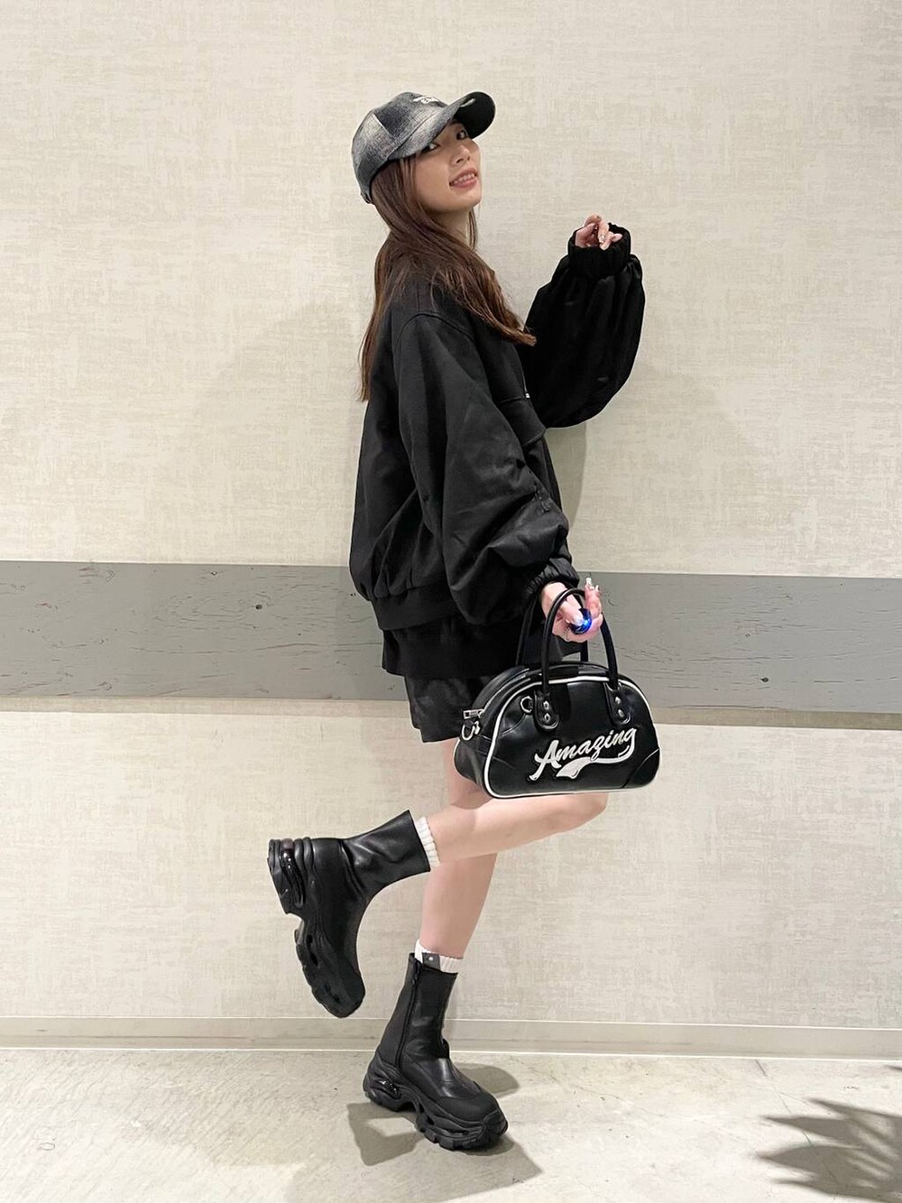 ブラック系のブルゾン、ブラック系のブーツ、ブラック系のショルダーバッグを着用したレディースの秋コーディネートの4枚目の写真