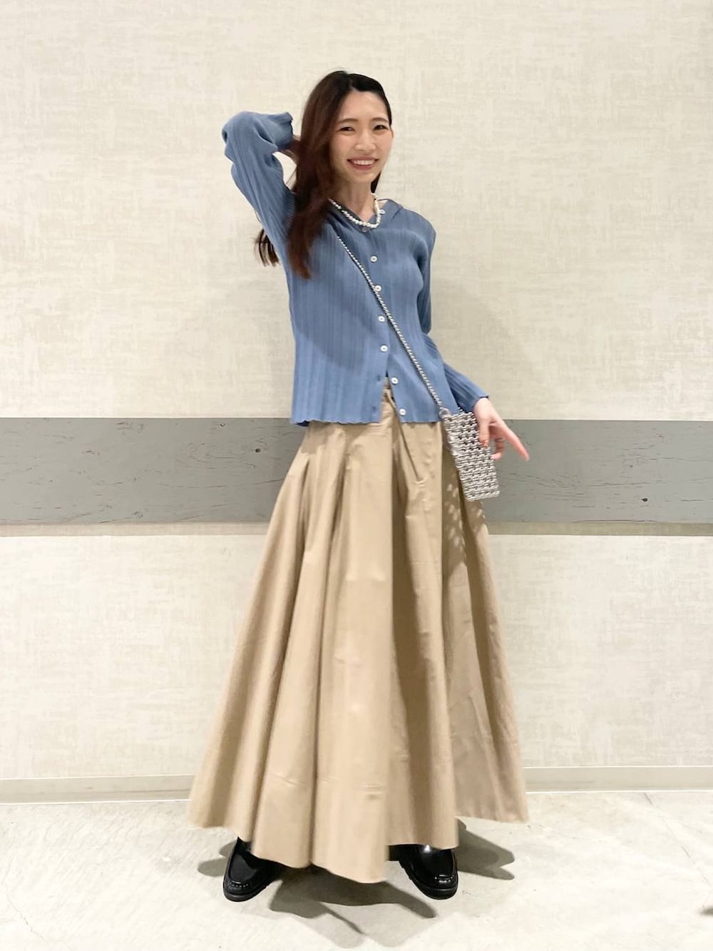 ベージュ系のスカート、ブラック系のローファー、ブルー系のカーディガン/ボレロを着用したレディースの春コーディネートの5枚目の写真