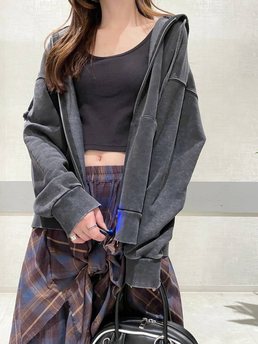 ブラック系のパーカー、ブラック系のローファー、ブラック系のショルダーバッグを着用したレディースの秋コーディネートの3枚目の写真