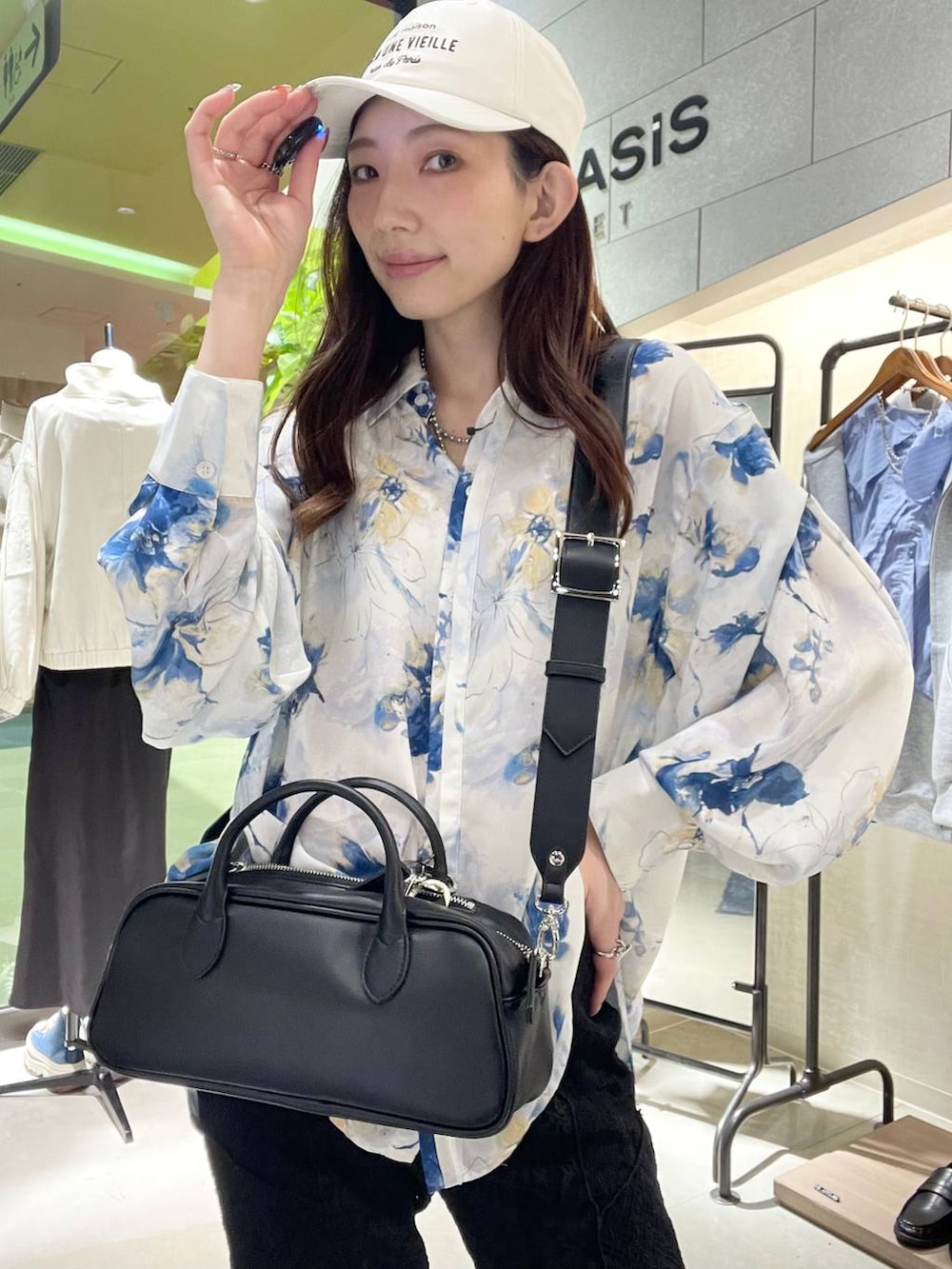 ブラウン系のボストンバッグ、ブラック系のローファー、ブラック系のその他パンツを着用したレディースの春コーディネートの6枚目の写真