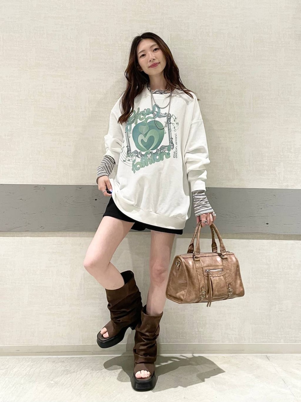 ホワイト系のTシャツ/カットソー、ブラック系のスウェットパンツ、ブラウン系のボストンバッグを着用したレディースの春コーディネートの5枚目の写真