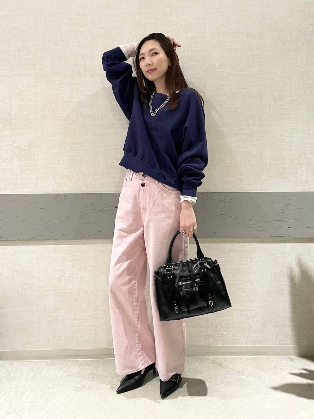 ブラック系のボストンバッグ、ブラック系のパンプス、ホワイト系のTシャツ/カットソーを着用したレディースの冬コーディネートの4枚目の写真