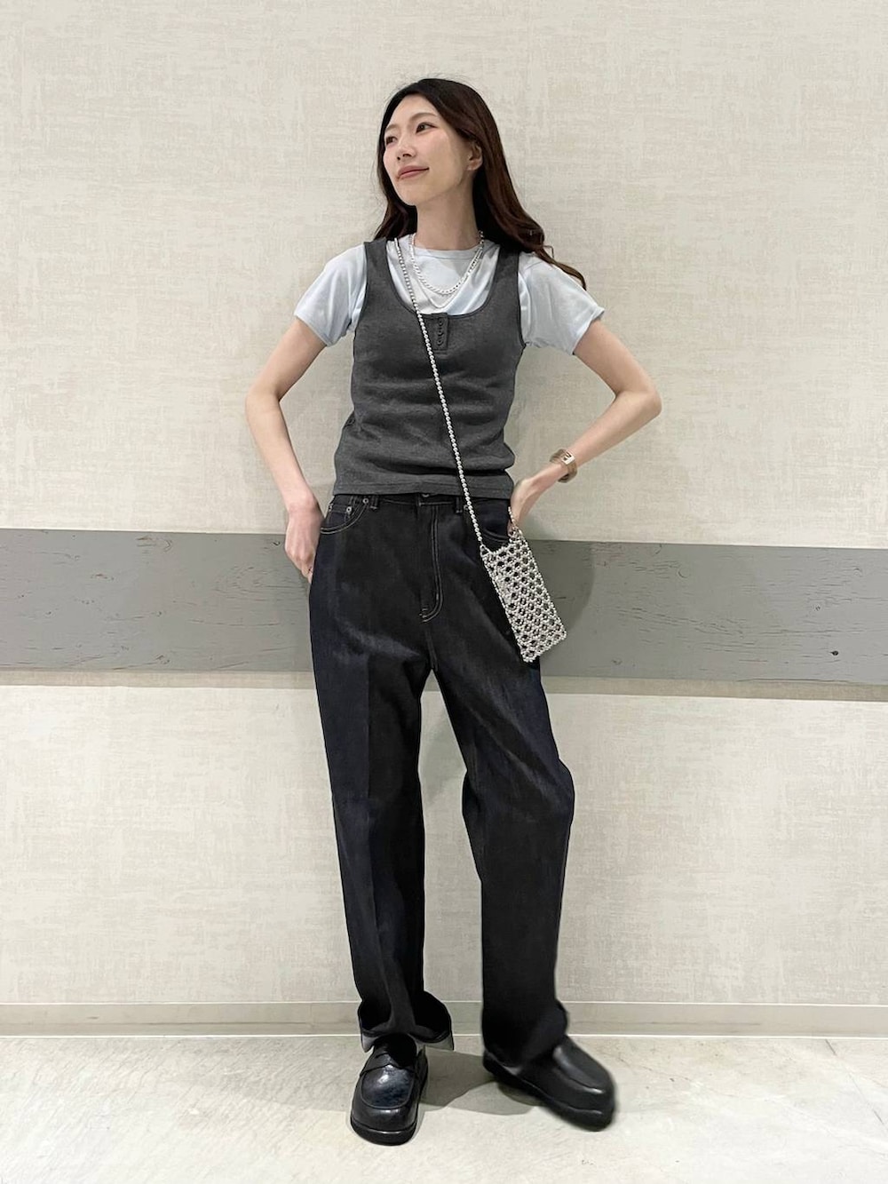 ブラック系のローファー、ブルー系のデニムパンツ、グレー系のタンクトップを着用したレディースの春コーディネートの2枚目の写真