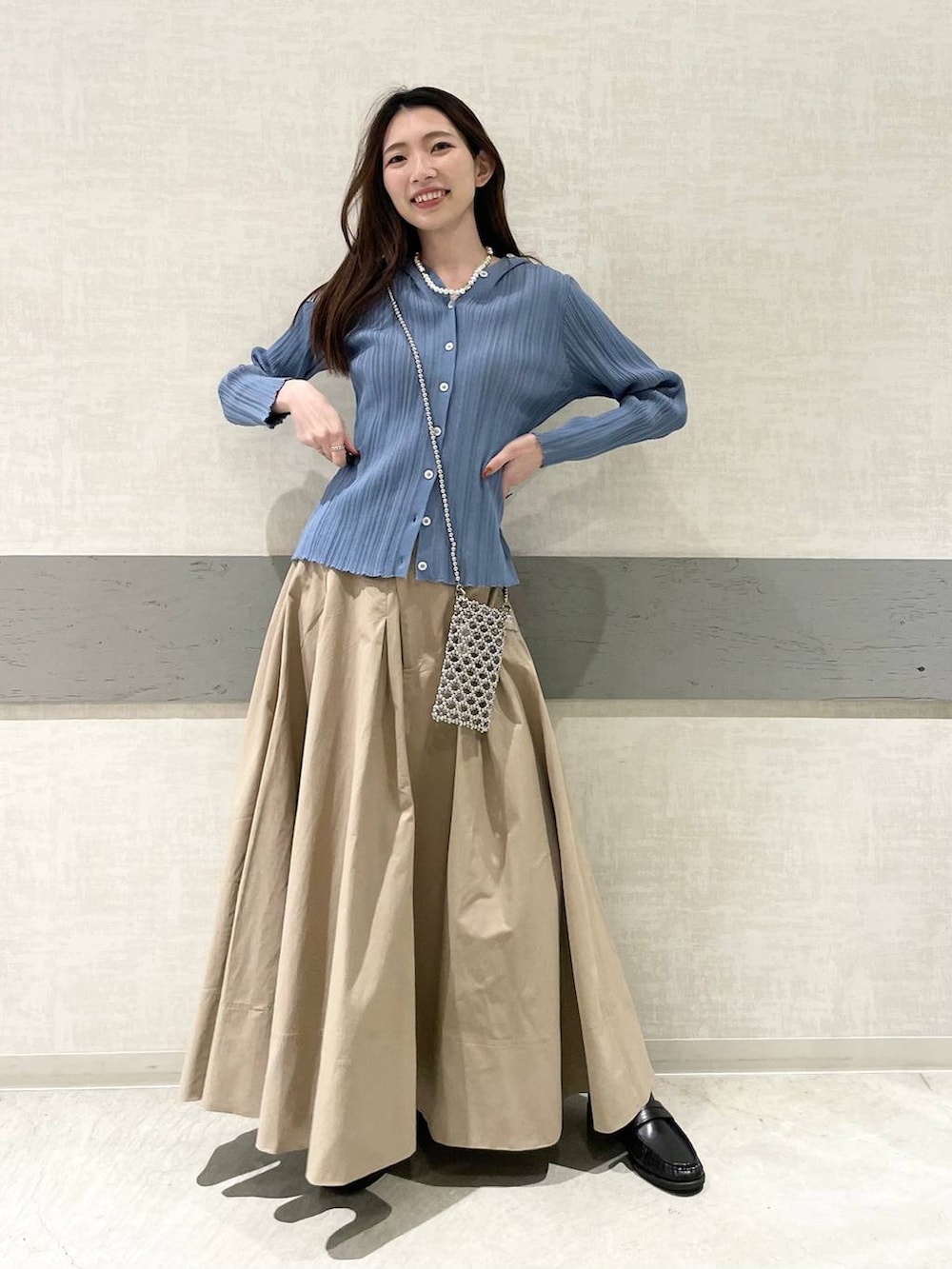 ベージュ系のスカート、ブラック系のローファー、ブルー系のカーディガン/ボレロを着用したレディースの春コーディネートの2枚目の写真