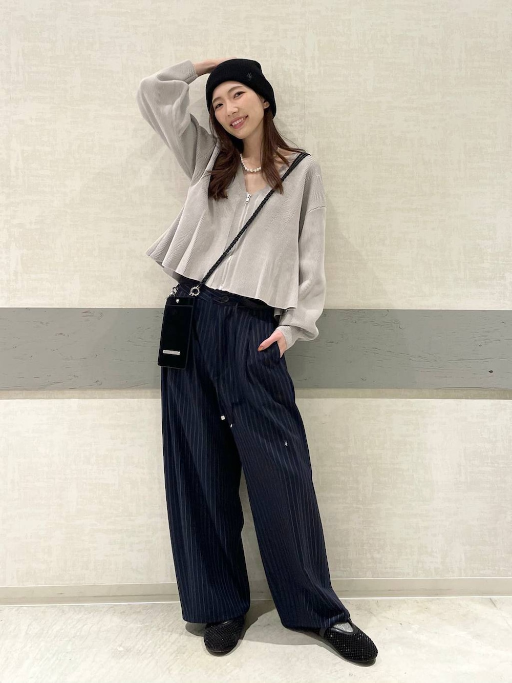 ブラック系のパンプス、ブルー系のスラックス、グレー系のカーディガン/ボレロを着用したレディースの春コーディネートの3枚目の写真