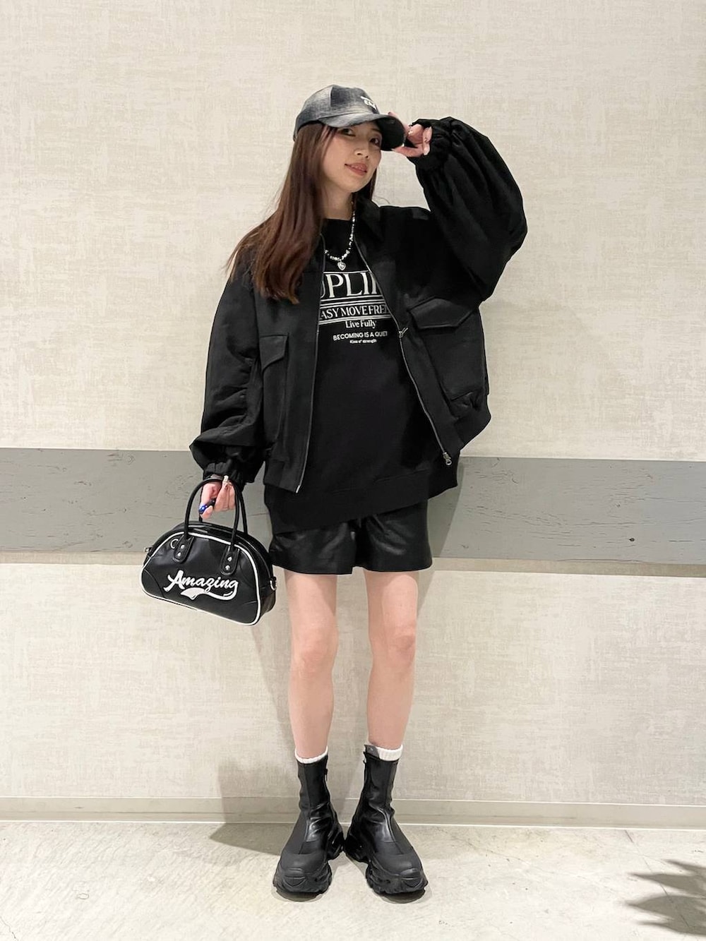 ブラック系のブルゾン、ブラック系のブーツ、ブラック系のショルダーバッグを着用したレディースの秋コーディネートの3枚目の写真